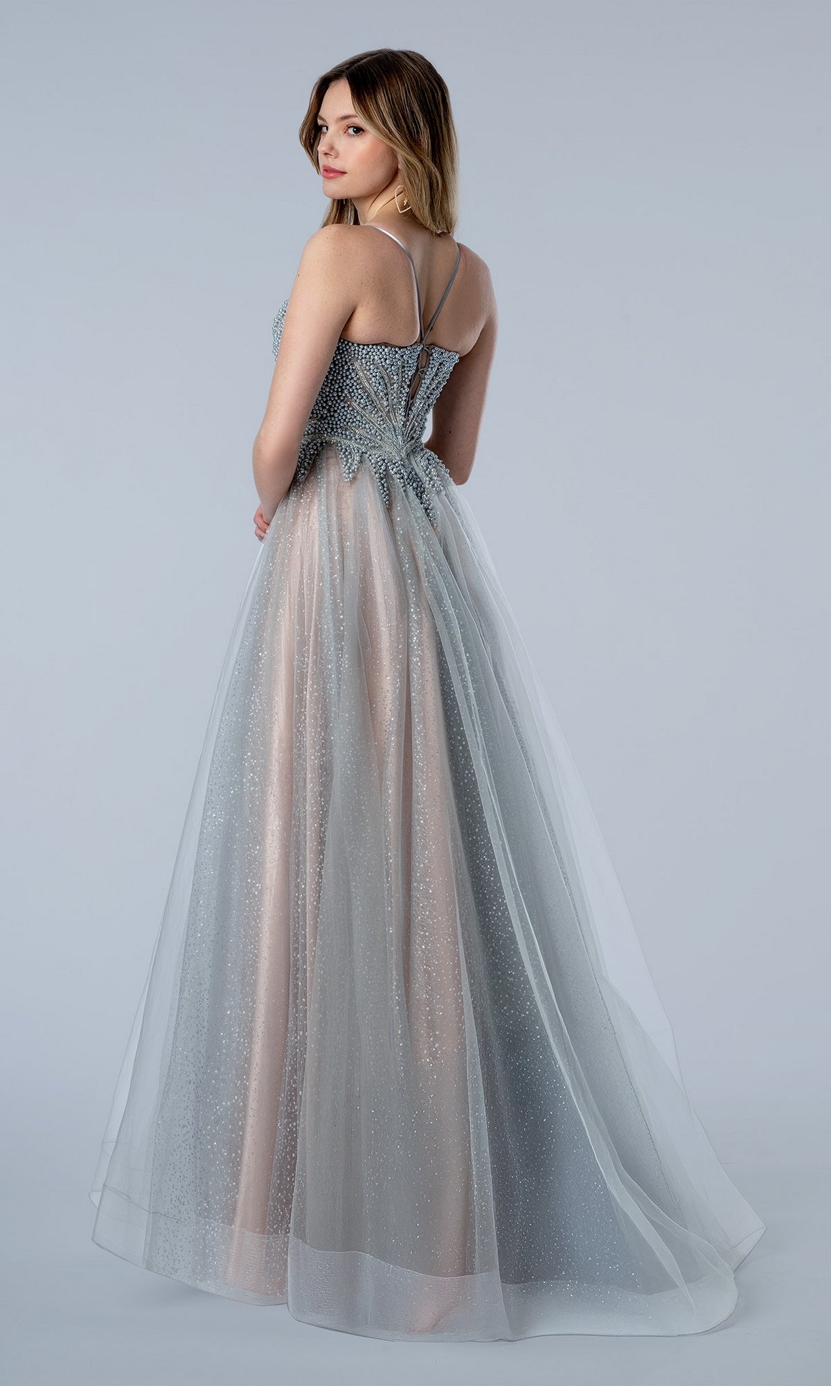 The Stella Couture 26112 long formal dress features a silver beaded bodice and a layered, shimmering tulle skirt.